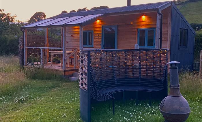 Handbuilt cabin with outdoor bath, set in an enchanting meadow, edge of the historic village of Llanfihangel y Creuddyn in Wales.